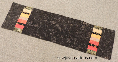 black batik runner with scrap strips